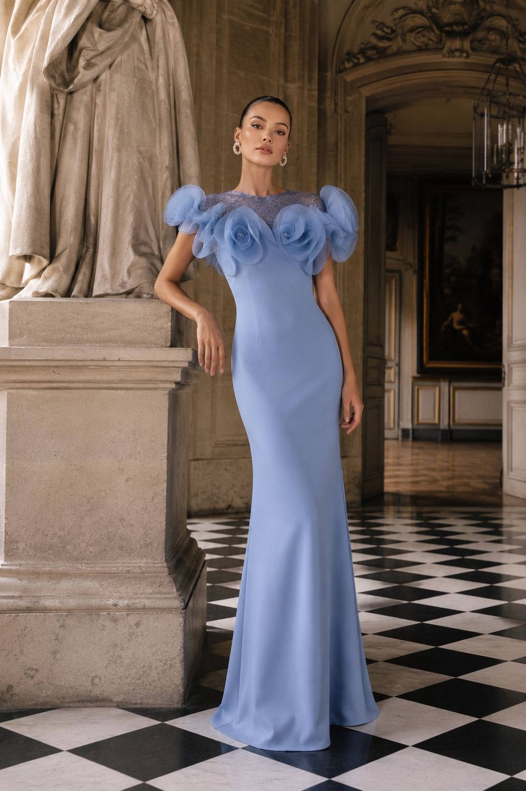 Donna in abito azzurro che posa in un elegante corridoio con pavimento a scacchi bianchi e neri.