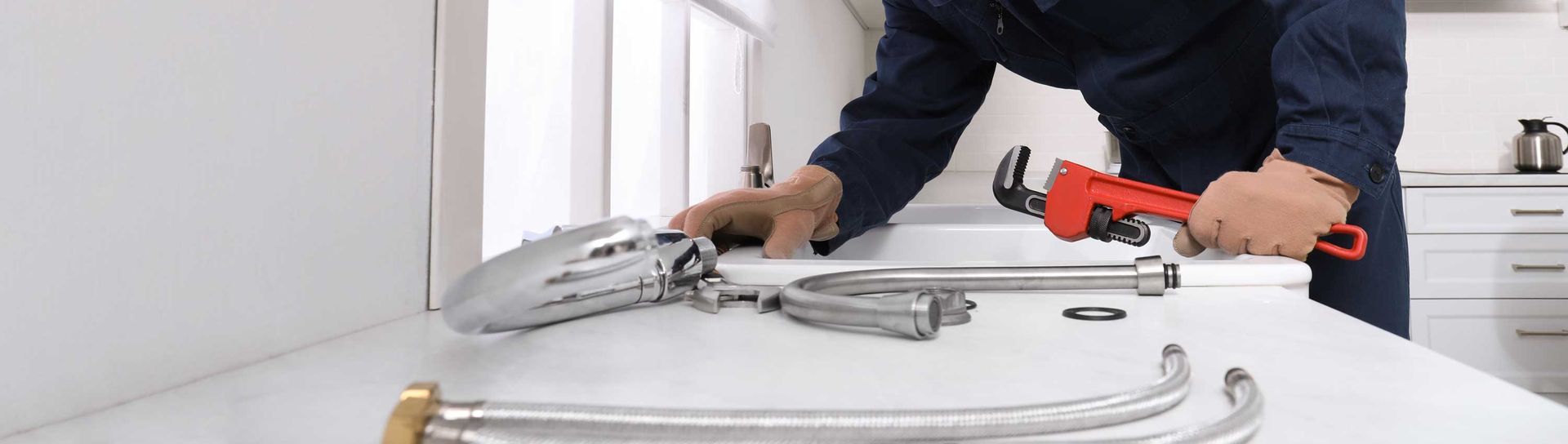 Plumber repairing a kitchen sink faucet, showcasing precision in commercial plumber service. Plumber repairing a kitchen sink faucet, showcasing precision in commercial plumber service.