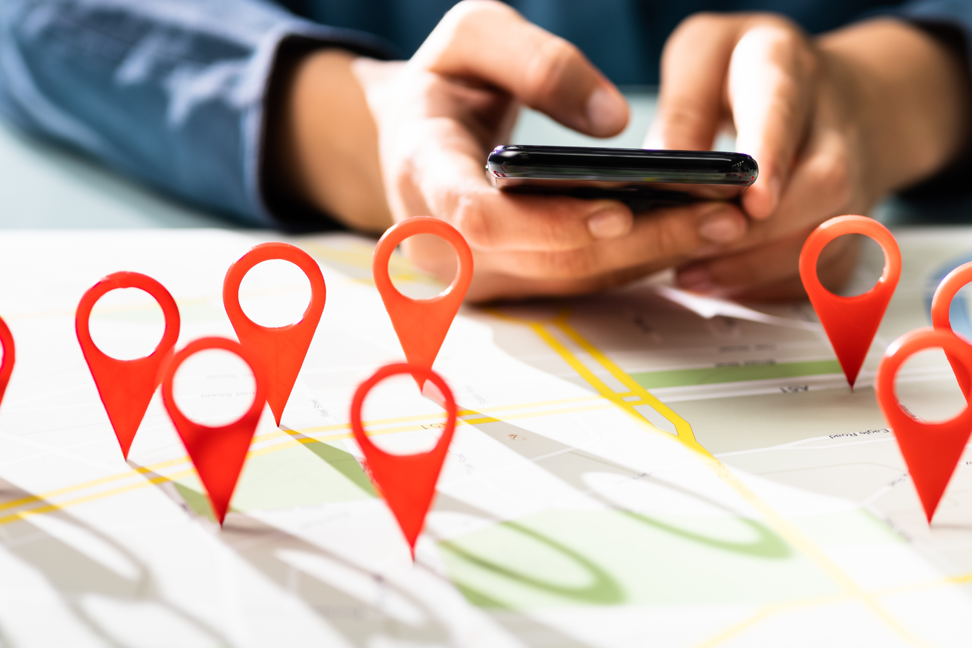A person is using a cell phone to find a location on a map.