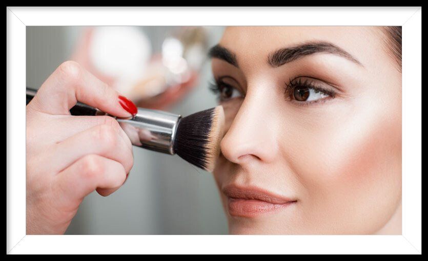 A woman is getting her makeup done by a makeup artist.