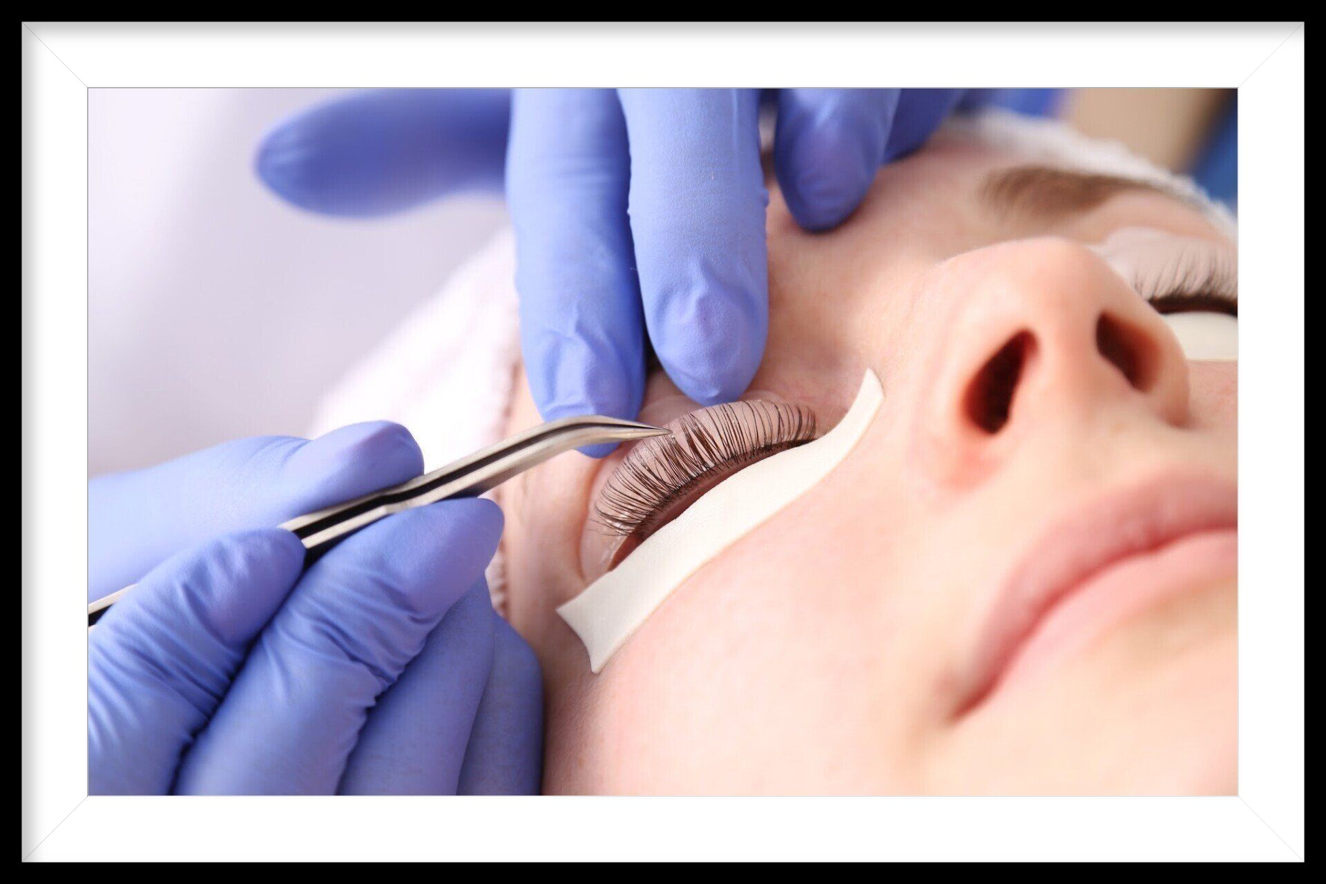 A woman is getting her eyelashes done at a beauty salon.
