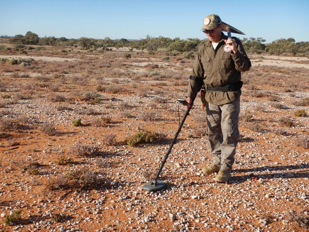 Man Using a Metal Detector in a Dry, Open Field — True Blue Camping Warehouse in North Mackay, QLD