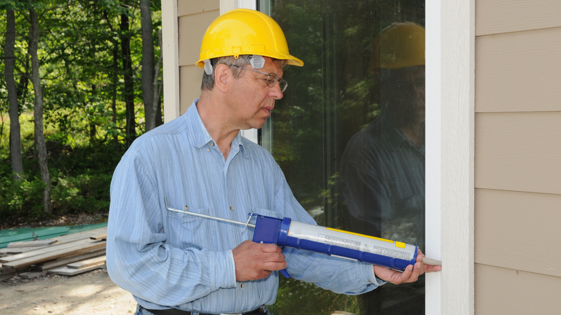 Picture of a windows store worker caulking a replacement window in Belleville Ontario.