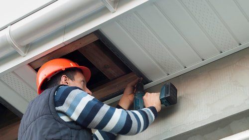 Picture of a contractor installing fascia on a house in Belleville Ontario.