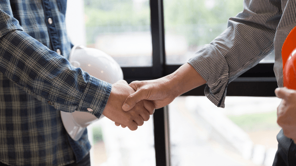 A windows contactor shaking hands with a customer.  The customer just ordered new replacement windows including a bay window, casement windows, and basement windows.