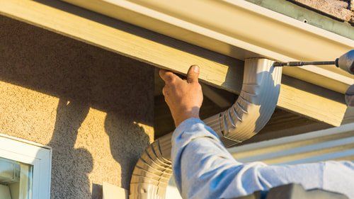 Picture of a worker installing fascia and soffit on an eavestrough in Belleville Ontario.