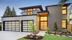Picture of a house with new windows and doors.  The house has black replacement windows and a new front door.