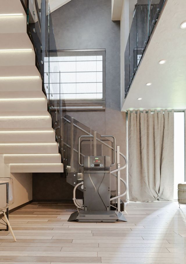 Interni moderni con scala e montascale. Pavimenti in legno chiaro e pareti neutre con ampie finestre.
