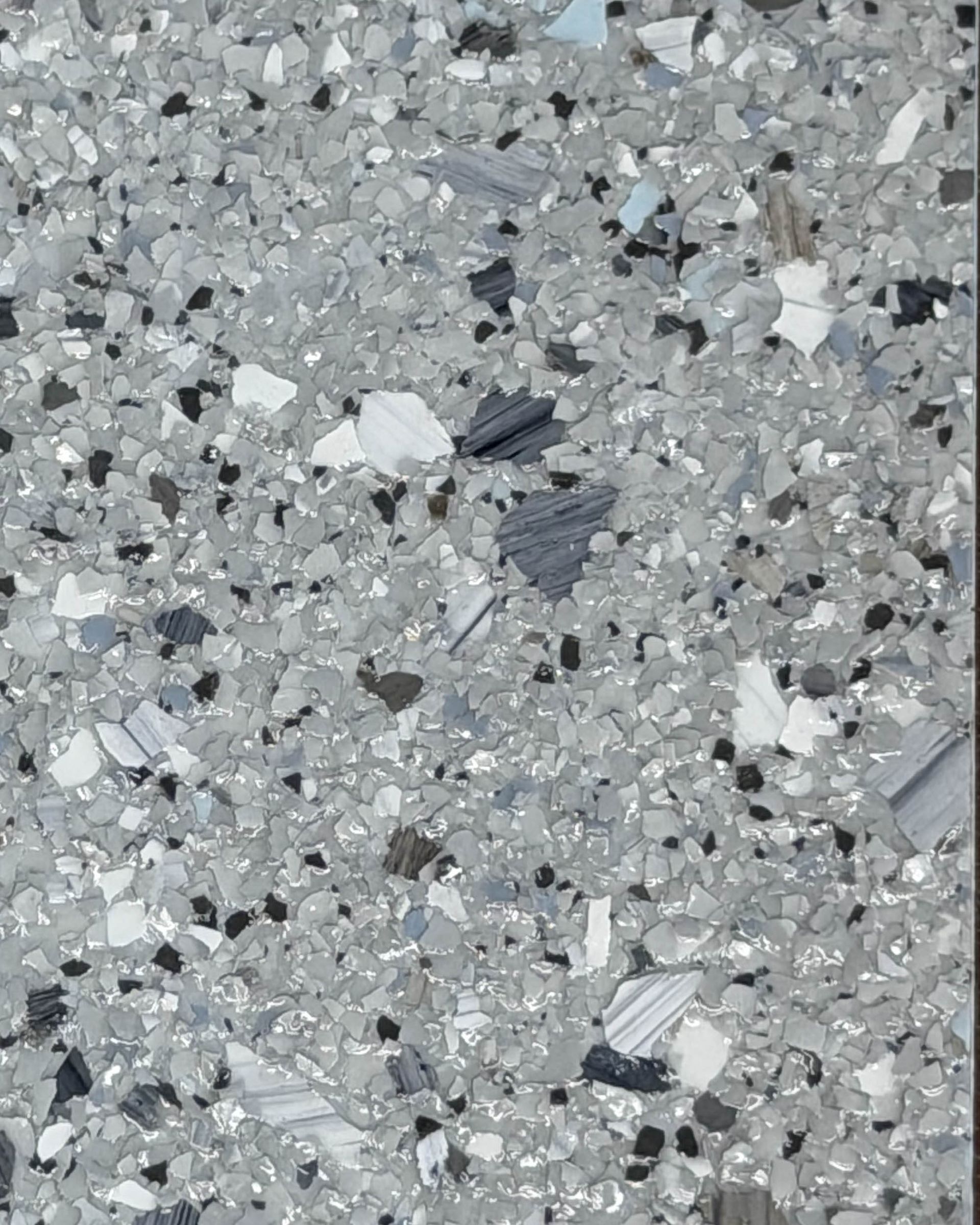 Gray speckled terrazzo surface with small white, black, and blue-gray chips