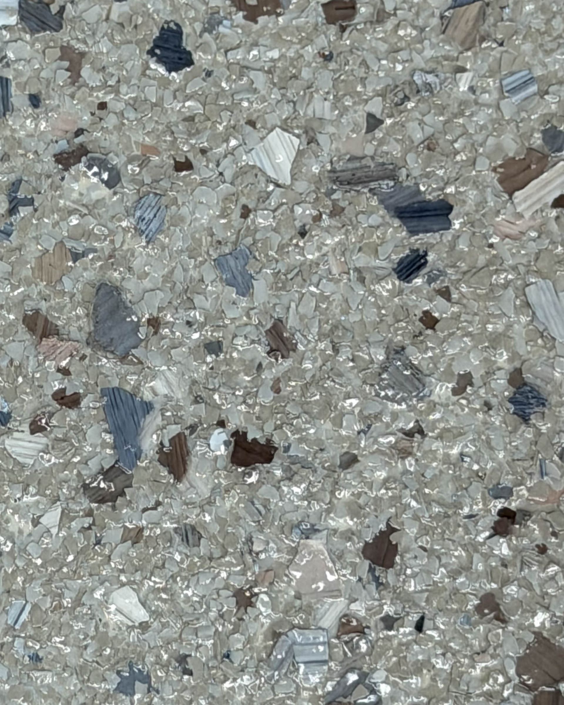 Close-up of speckled gray and white stone or terrazzo surface with small dark flecks