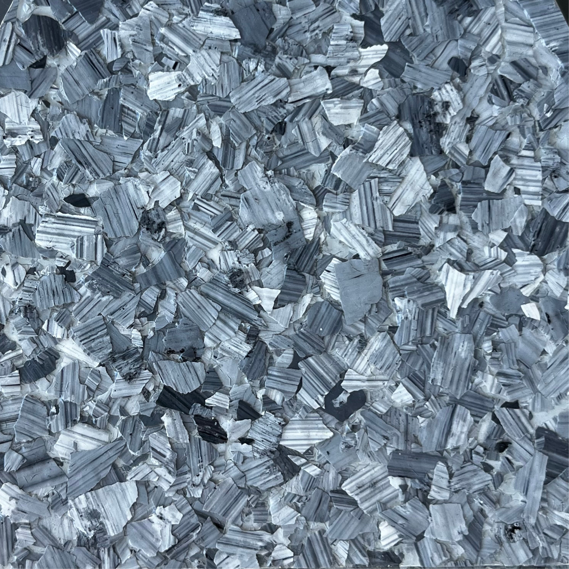 Close-up of silvery-gray metallic shards or crystals with a rough, textured surface