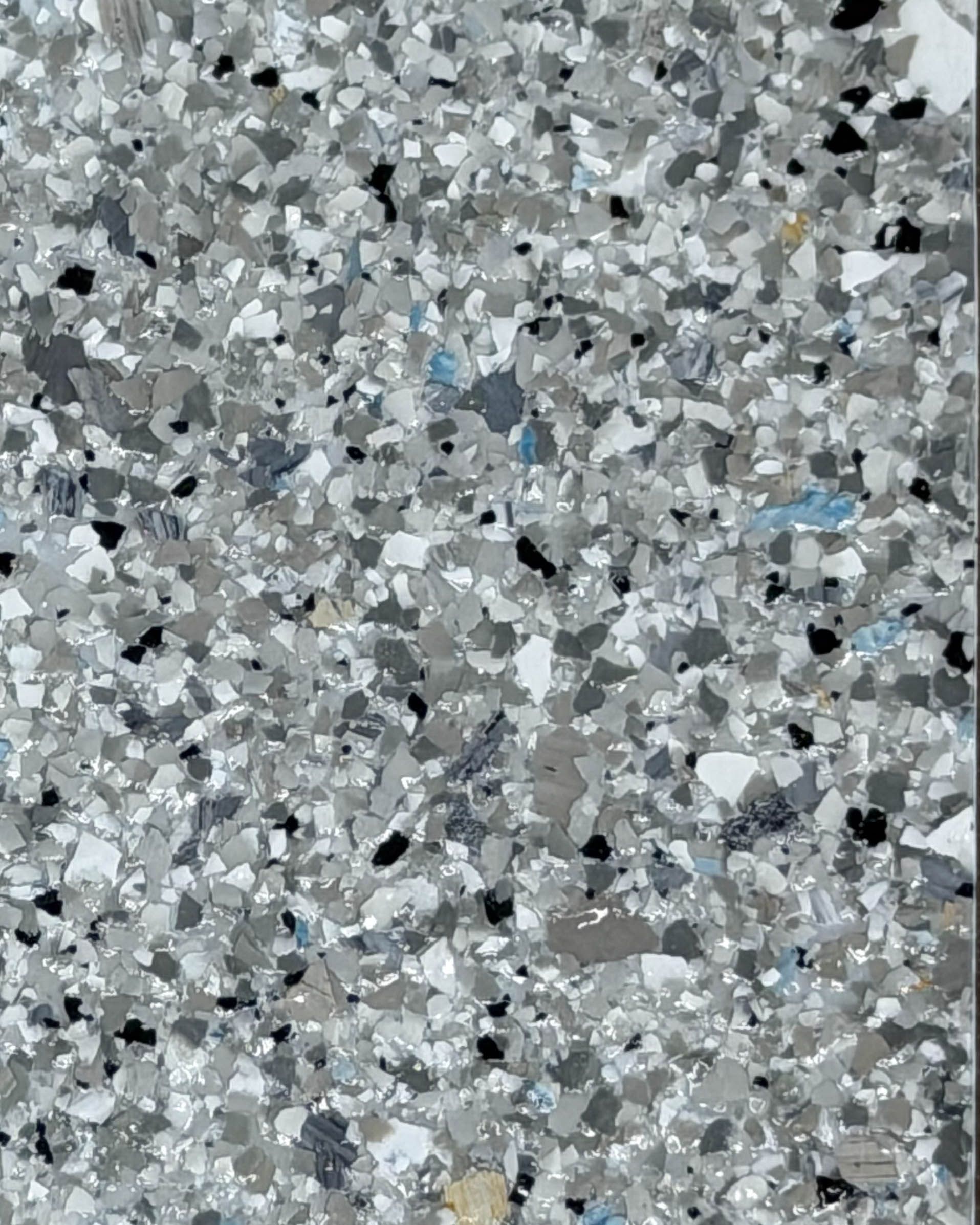 Close-up of a gray speckled terrazzo or concrete surface with small white and blue flecks