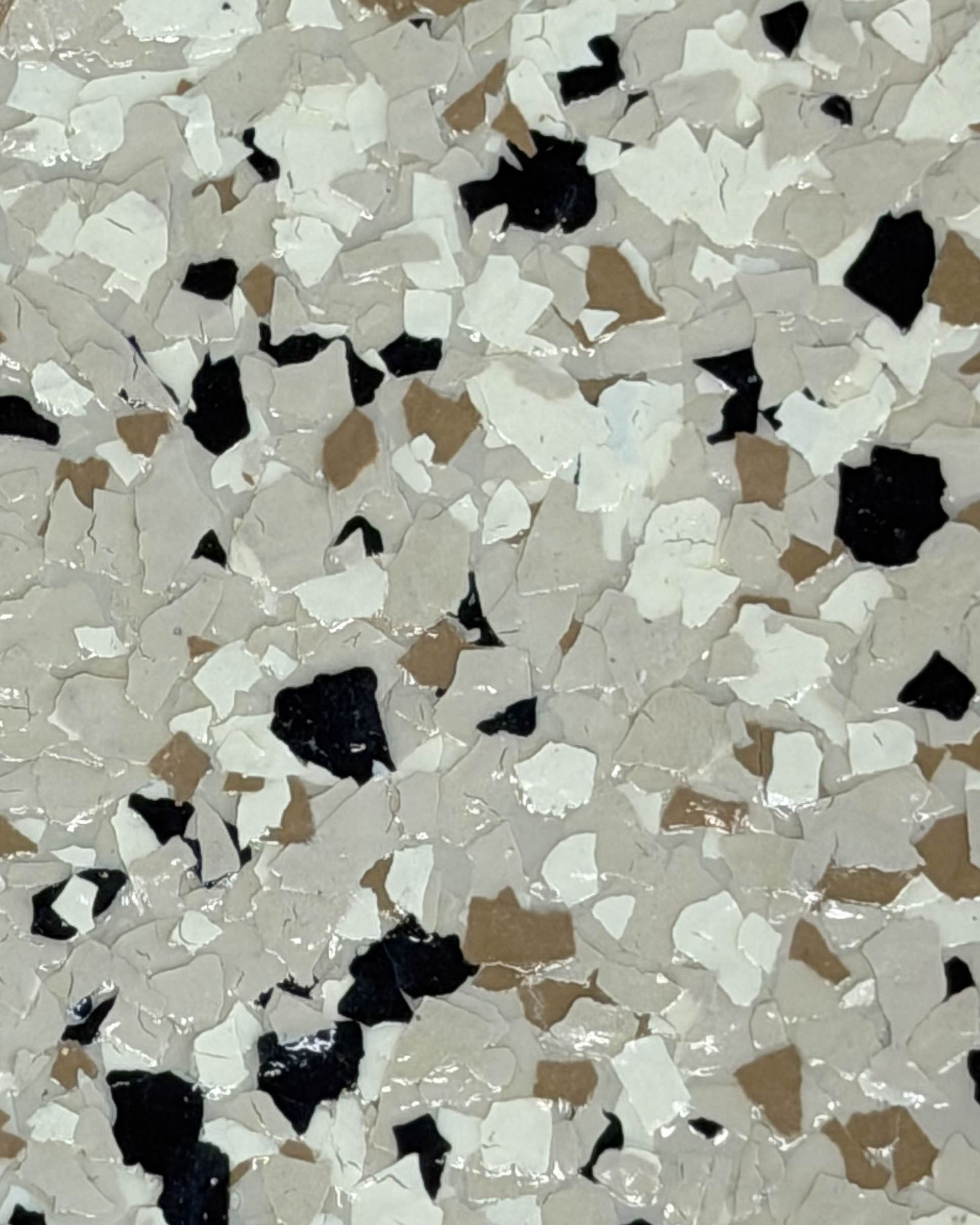 Close-up of a speckled terrazzo surface with white, beige, and black stone chips