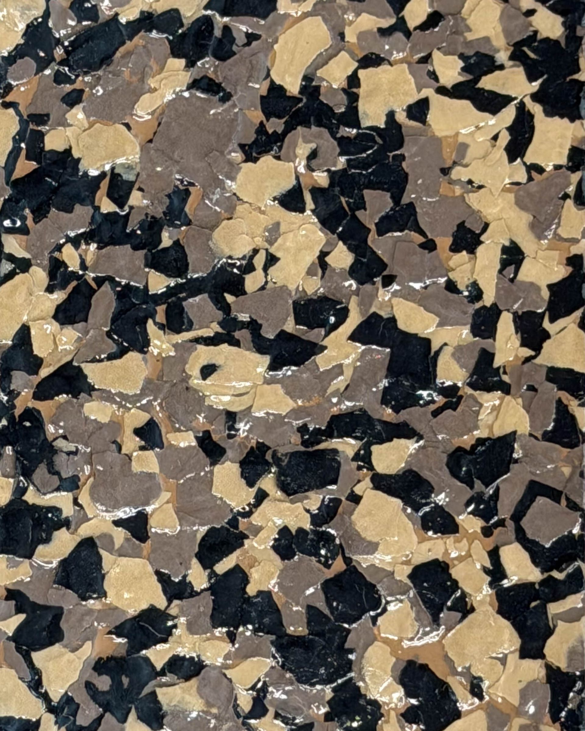 Close-up of a tan, black, and gray speckled stone or terrazzo surface
