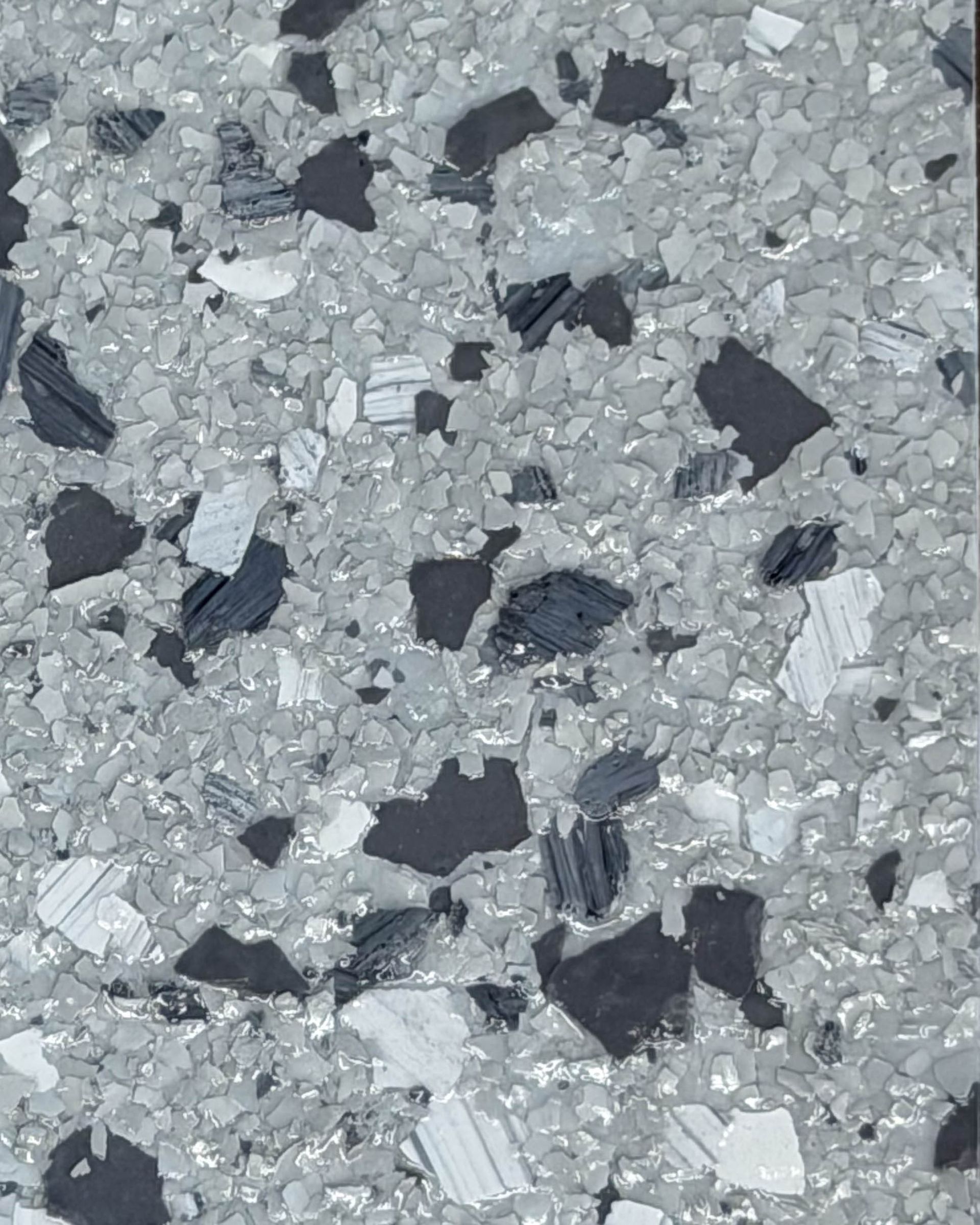 Gray speckled terrazzo surface with scattered black and white stone chips