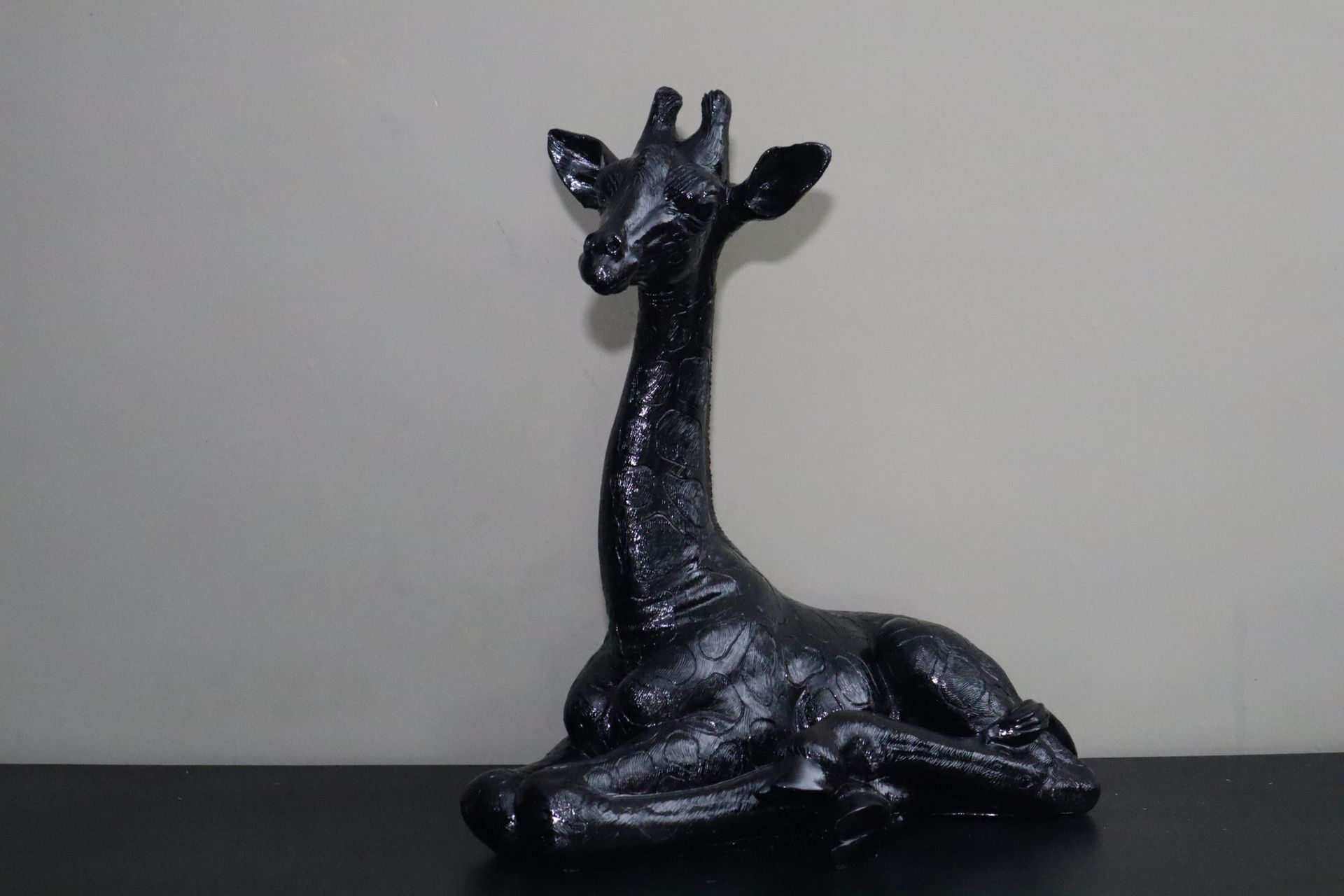 Giraffe beeld zwart liggend 57 cm tuinbeeld dierenbeeld decoratie