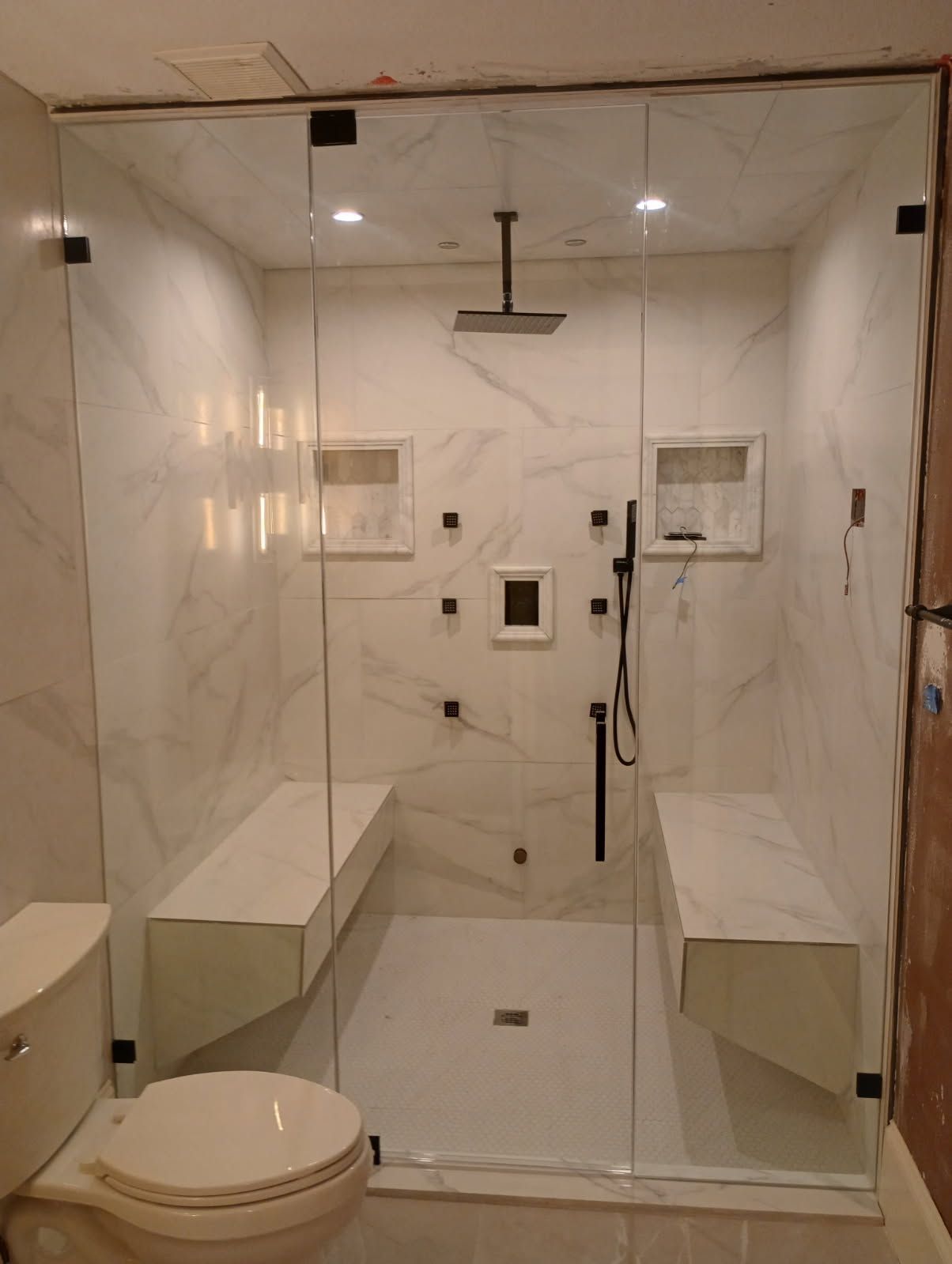 Frameless glass shower enclosure