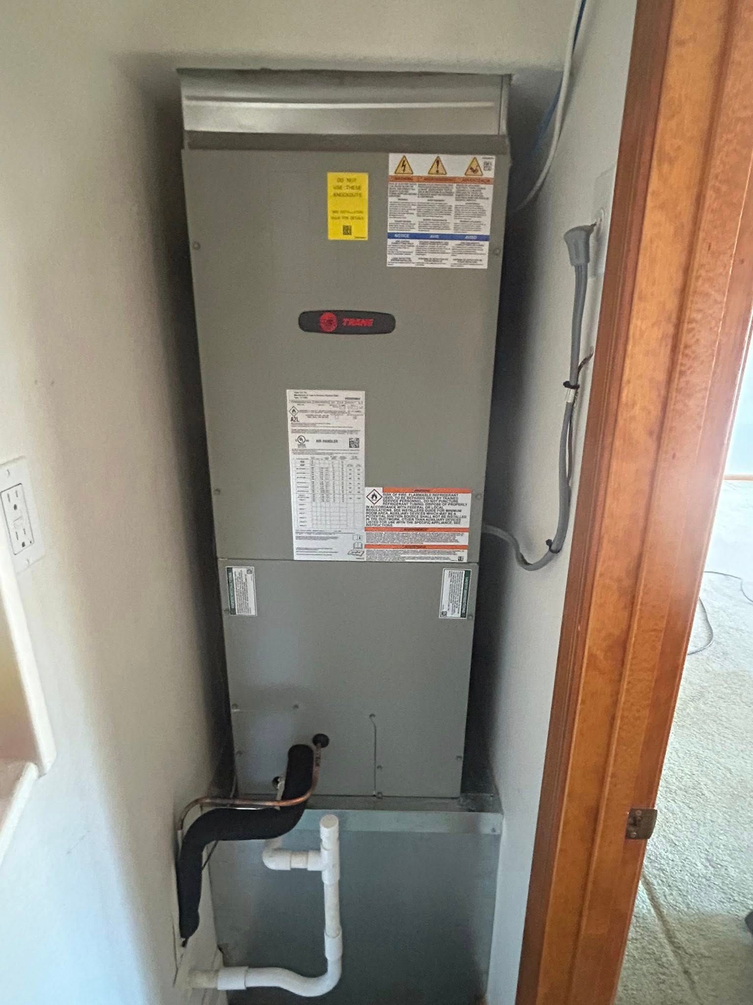 Gray HVAC furnace unit in a narrow utility closet in Phoenix AZ