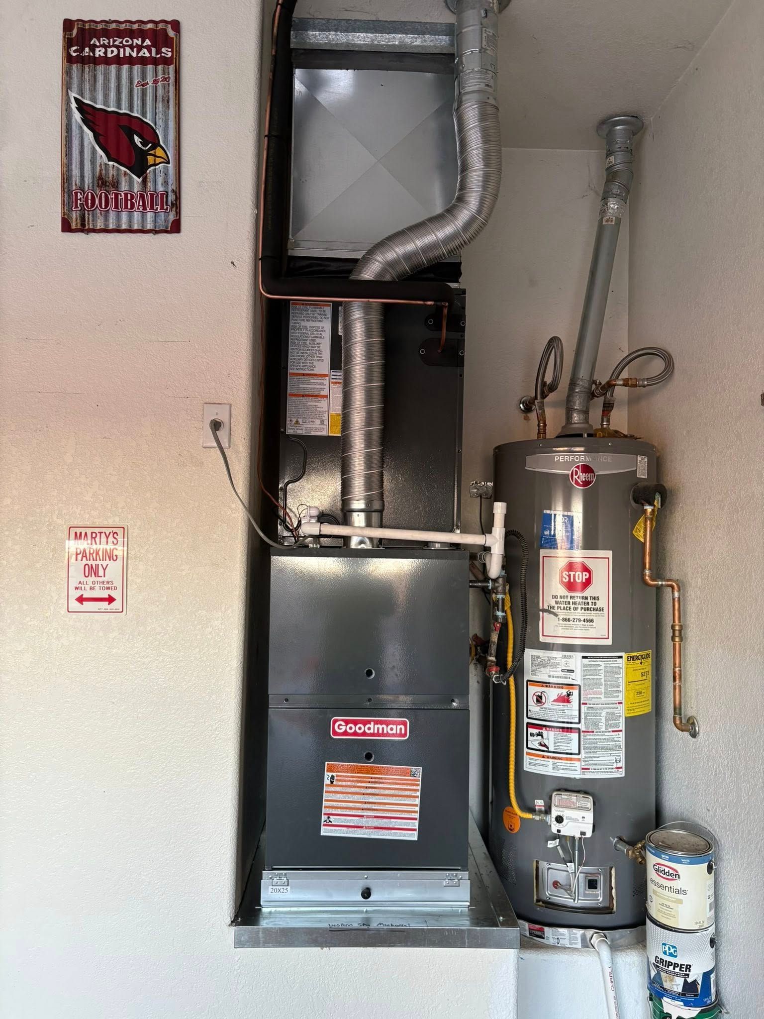 HVAC and water heater in a utility closet with exposed ductwork and pipes
