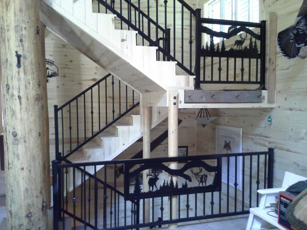 Wooden staircase with black metal railings, including decorative cutouts of wildlife.