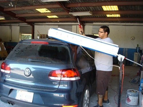 A man is working on a volkswagen in a garage