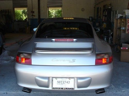A silver porsche is parked in a garage