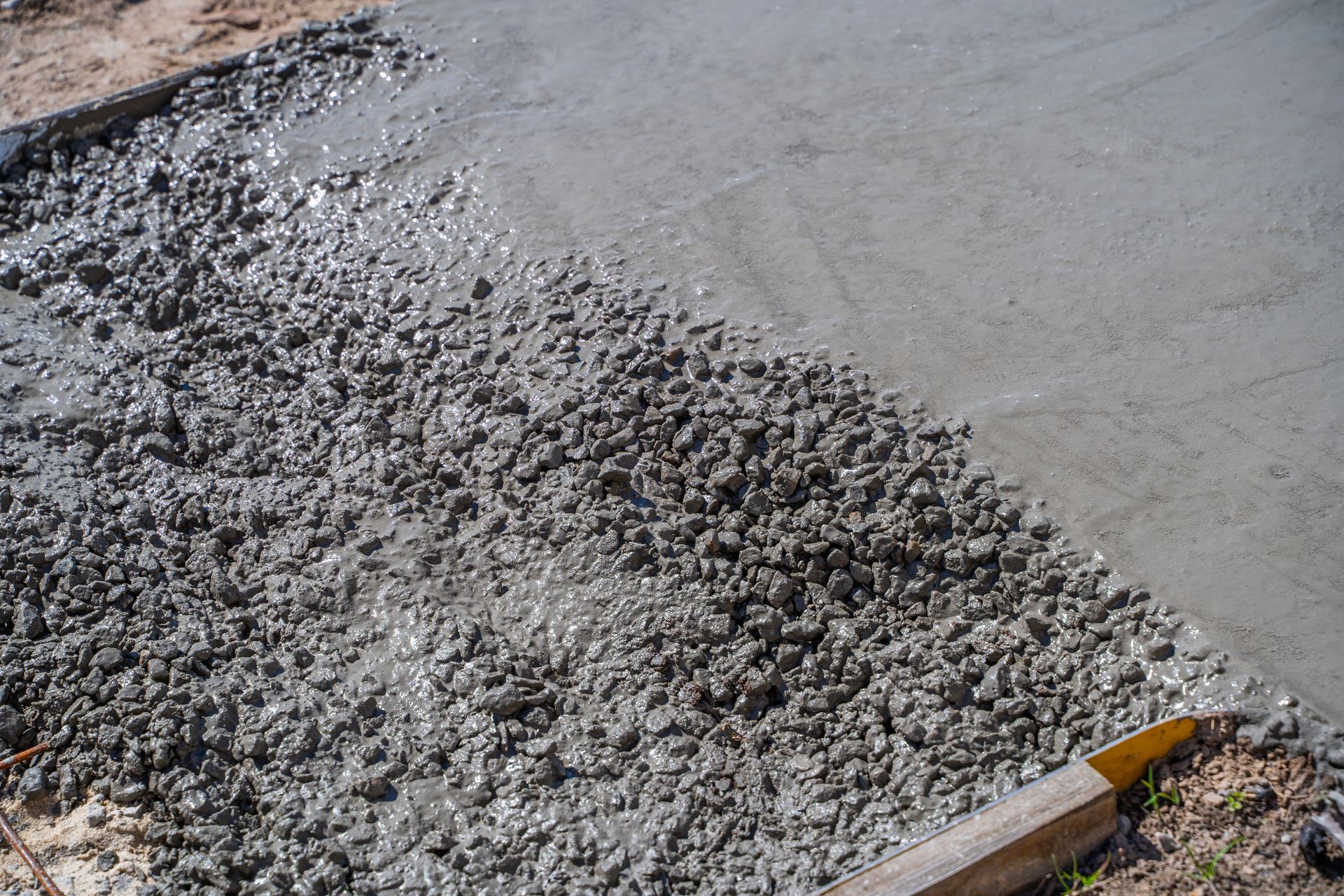 The process of pouring concrete on a path, close-up. The process of pouring concrete on a path, close-up.
