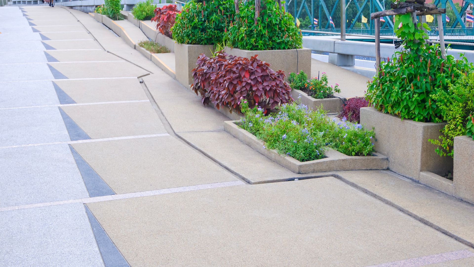 Exposed aggregate finish cobblestone floor of elevated walkway with ornamental plants decoration.