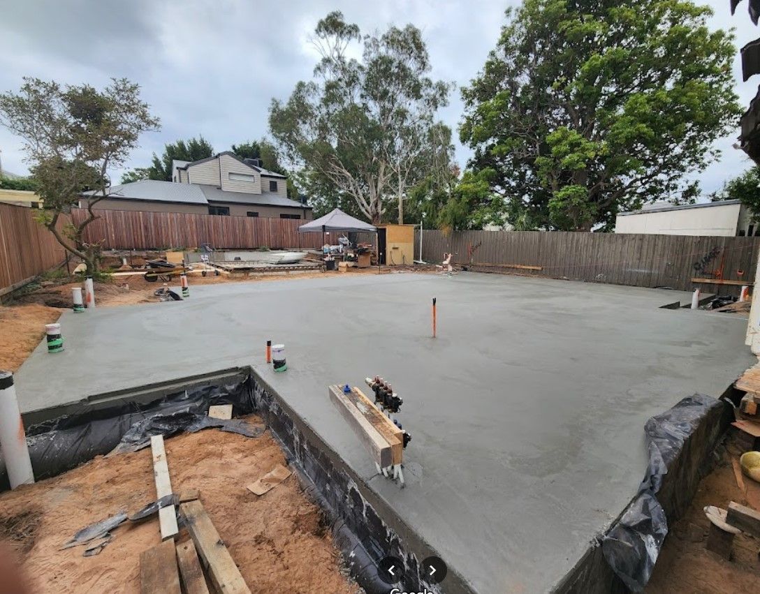 A concrete foundation is being built in a backyard.