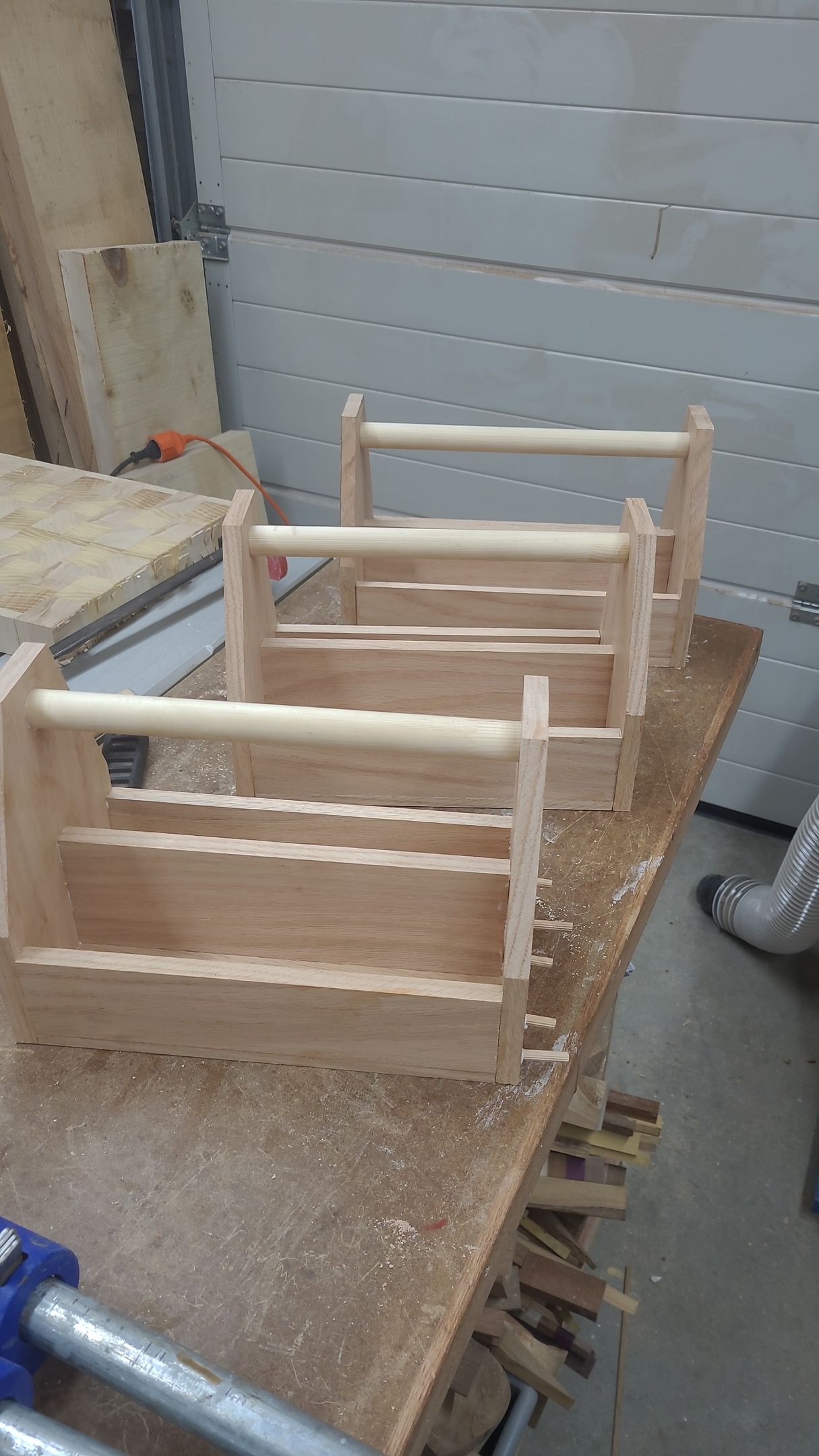 Twee onafgewerkte houten kratframes op een werkbank in een werkplaats.