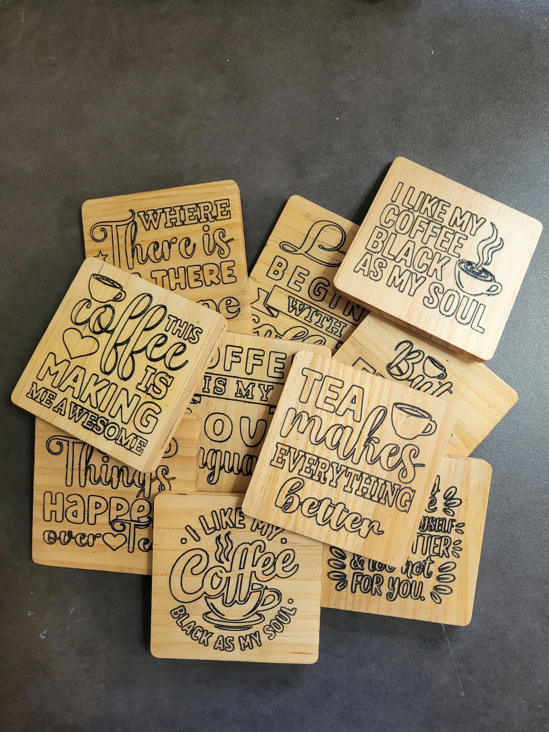 Stapel kleine vierkante houten onderzetters met zwarte handgetekende doodles en letters
