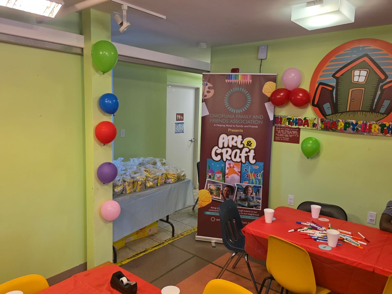 Party room with balloons, table settings, and