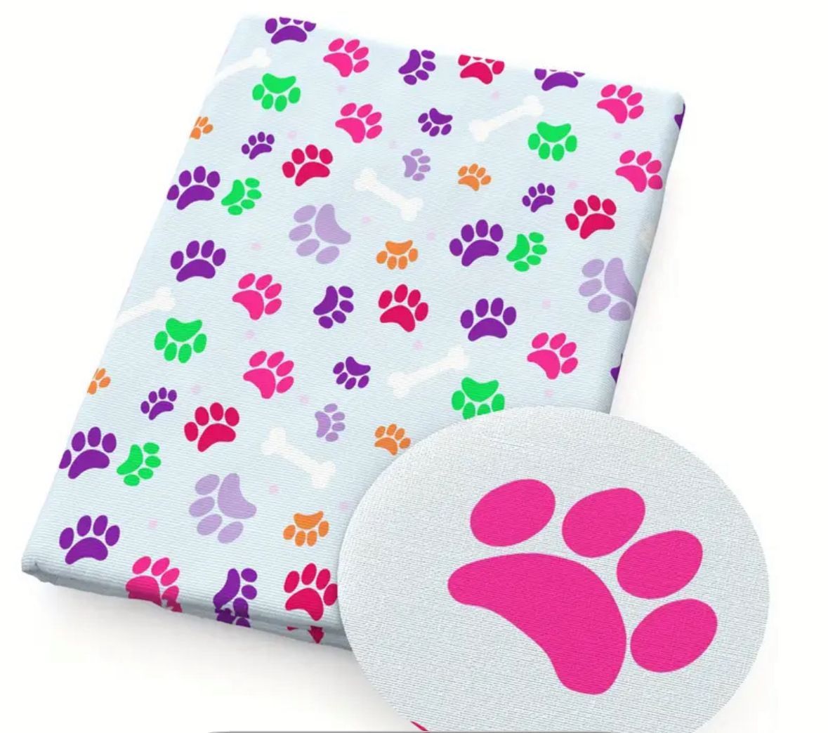 Light blue blanket with colorful paw prints and bone shapes.