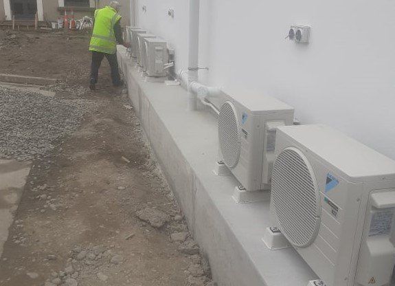 Row of Daikin outdoor heat pump units installed.