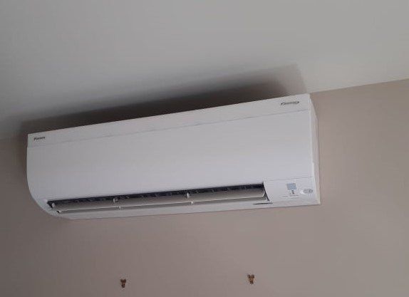 Hi-wall heat pump installed on wall.