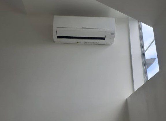 Hi-wall heat pump installed on wall.
