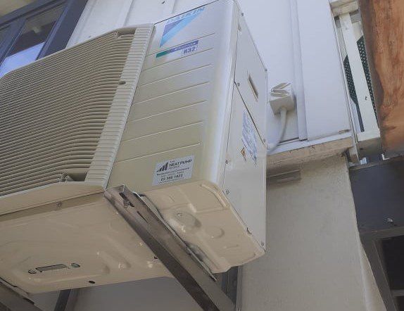 Daikin outdoor heat pump installed on brackets.