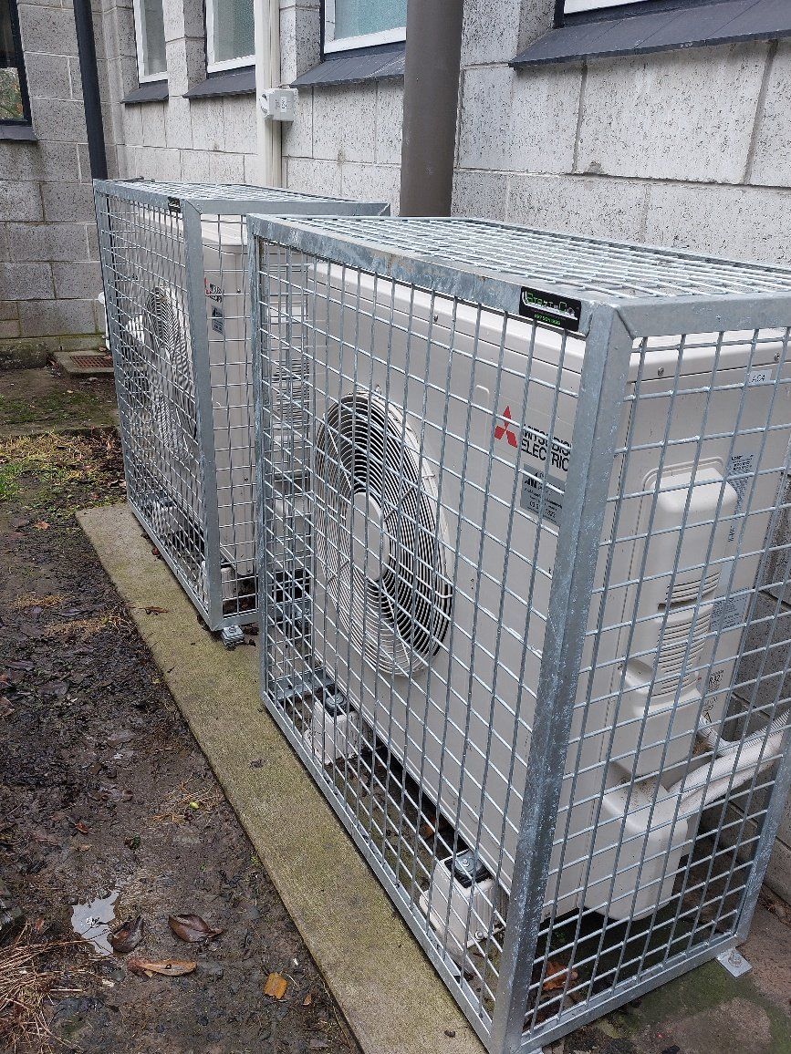 Mitsubishi Electric heat pump outdoor units with metal security cages.