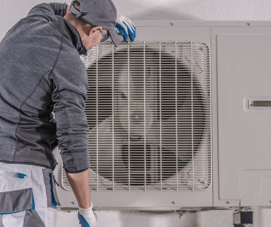 Air conditioning technician reviewing outdoor heat pump unit.