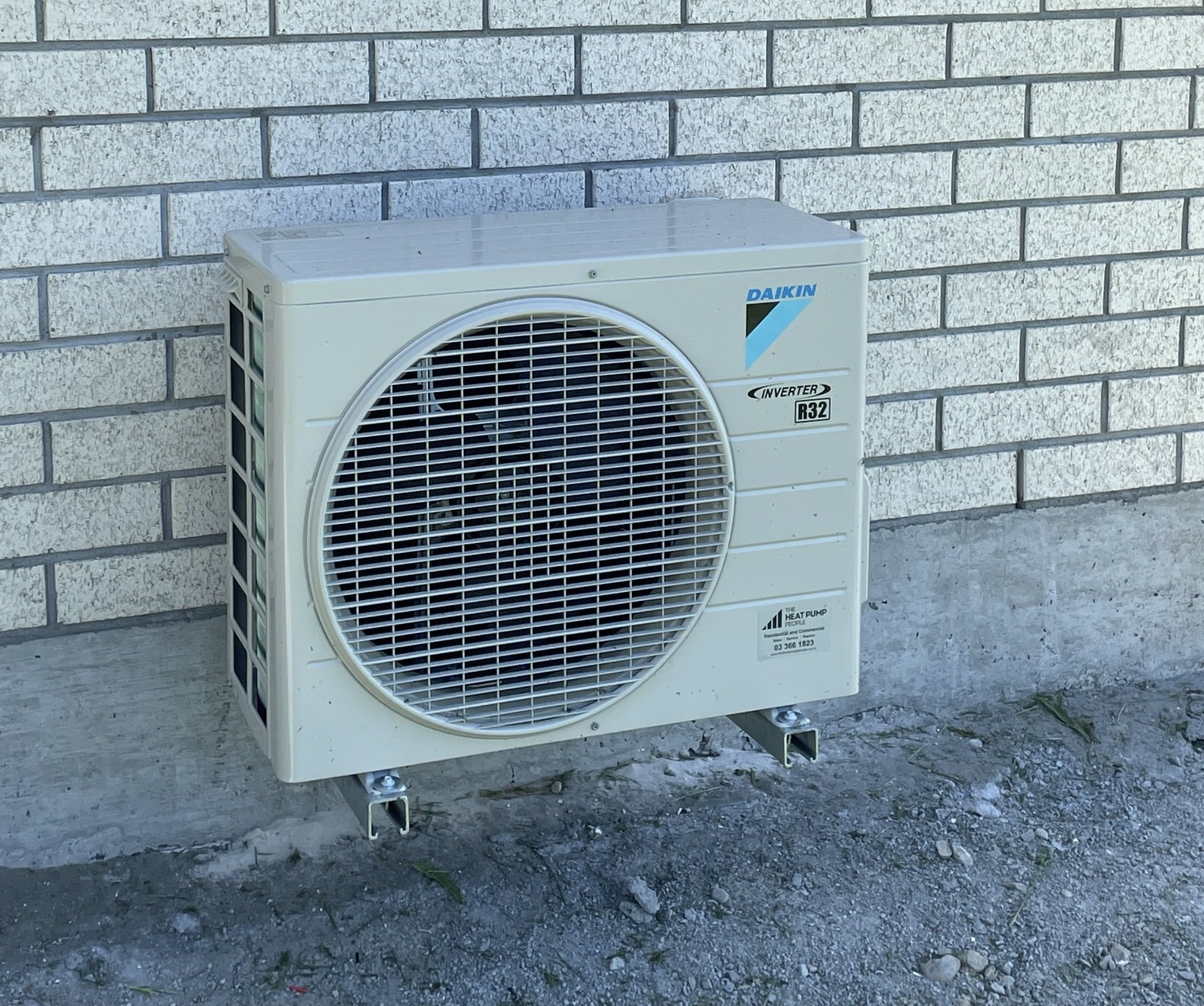 Daikin outdoor heat pump unit installed on brick wall