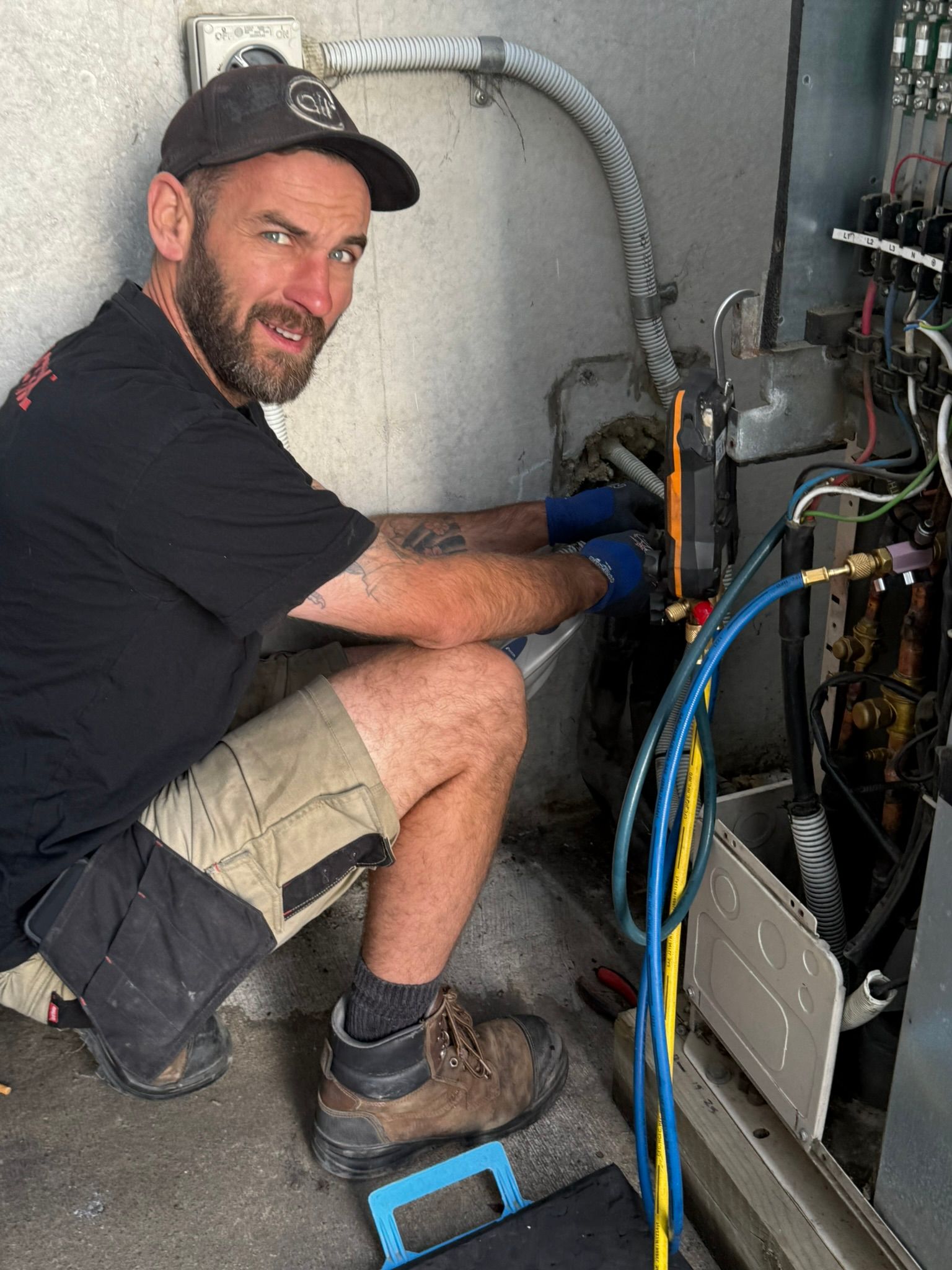 Installation technician from The Heat Pump People installing an external heat pump unit