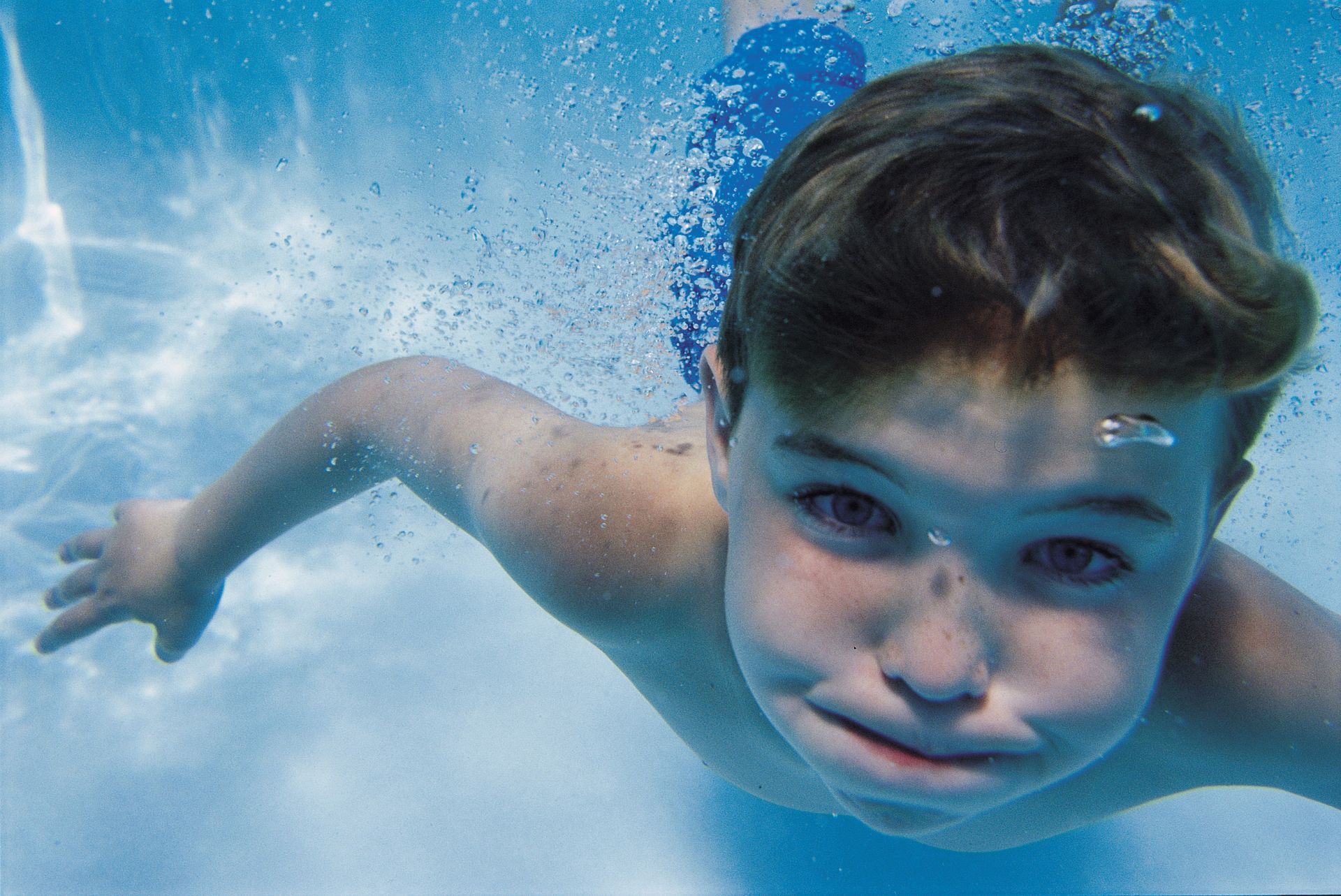 Boy under water in swimming pool.