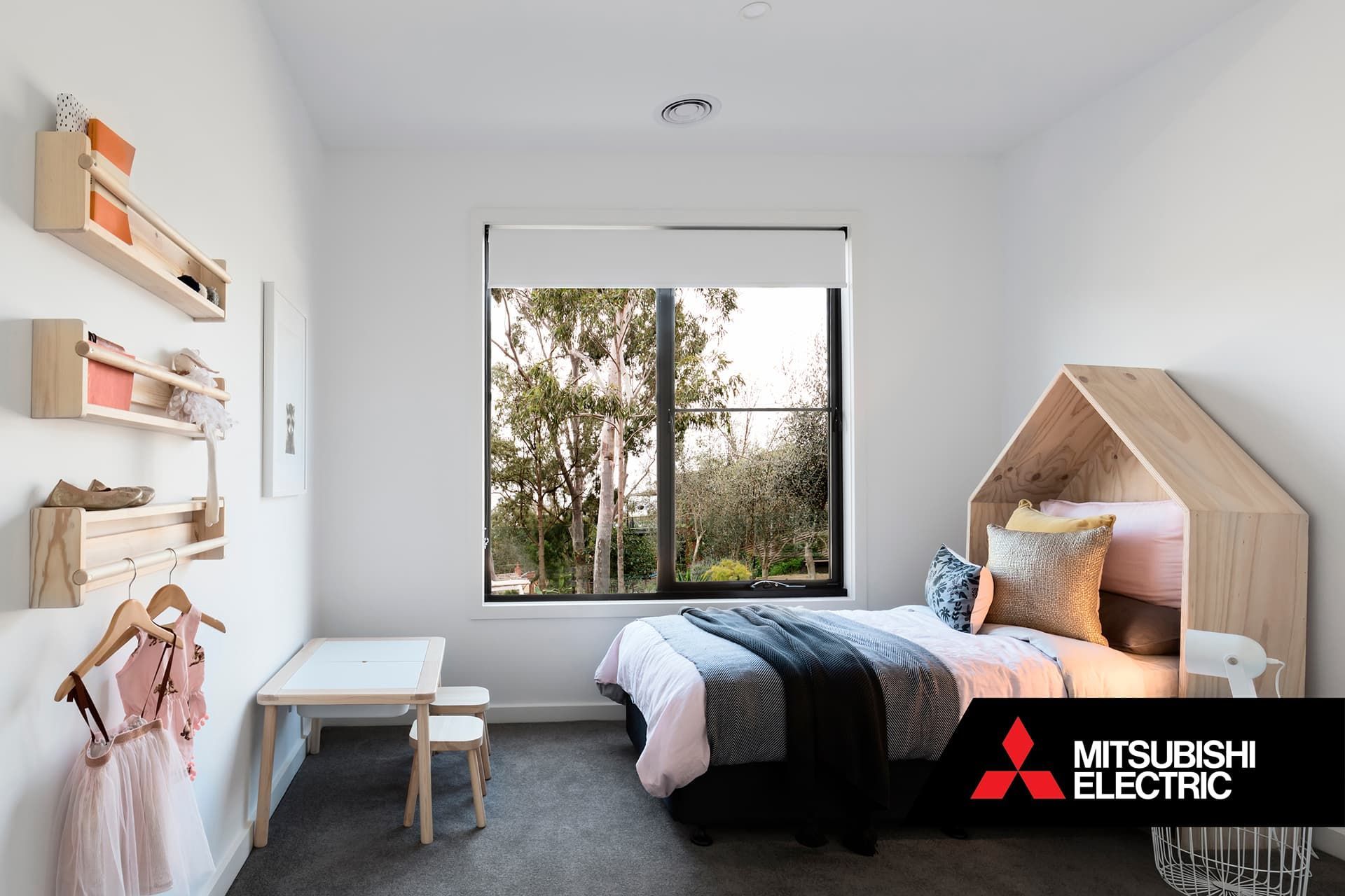 Child's bedroom with single bed and house headboard, with ducted heat pump vents.