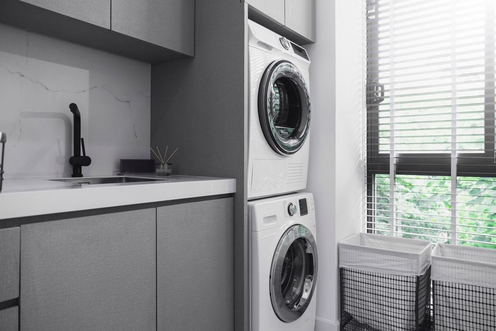 A Laundry Room With a Washer and Dryer Stacked on Top of Each Other — Bradmark Appliance Service in Garbutt, QLD