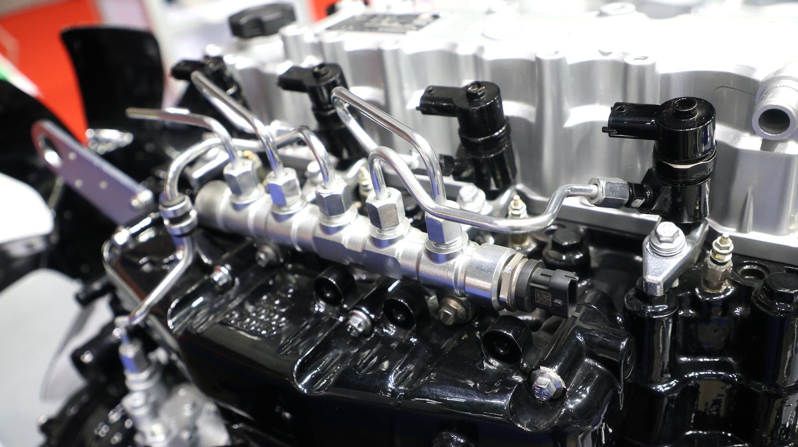 Close-up of a shiny black engine with silver fuel rails and black ignition coils