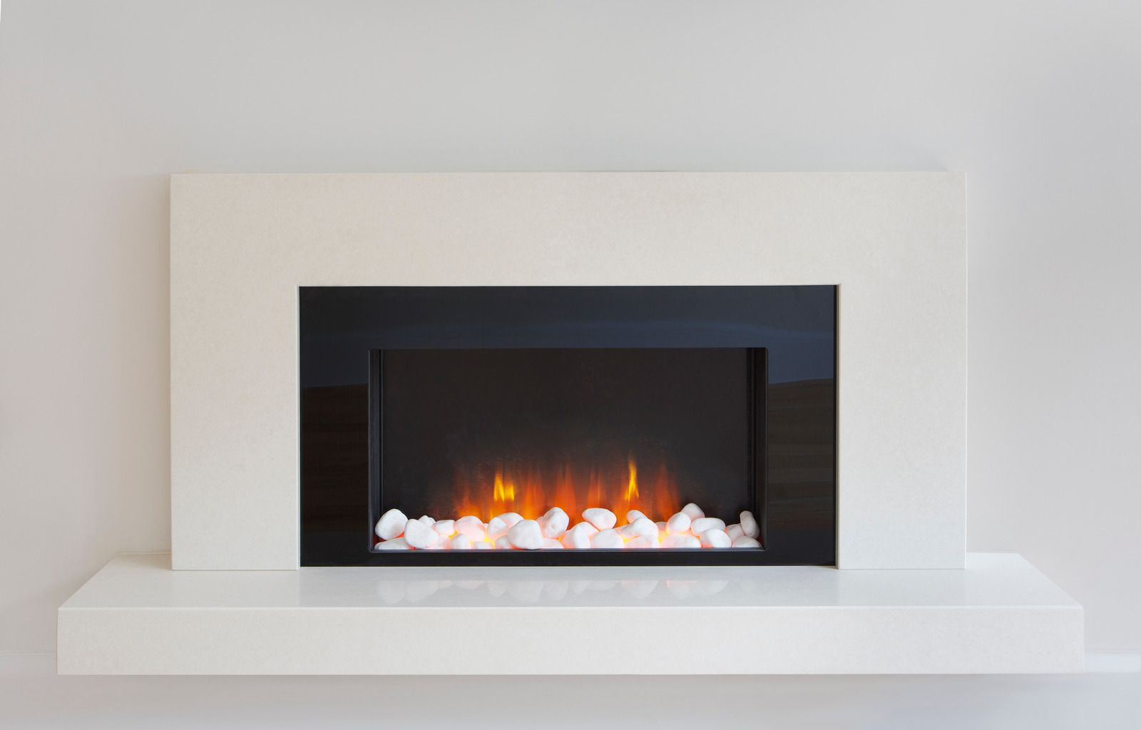 White wall-mounted electric fireplace with orange flames and white pebbles