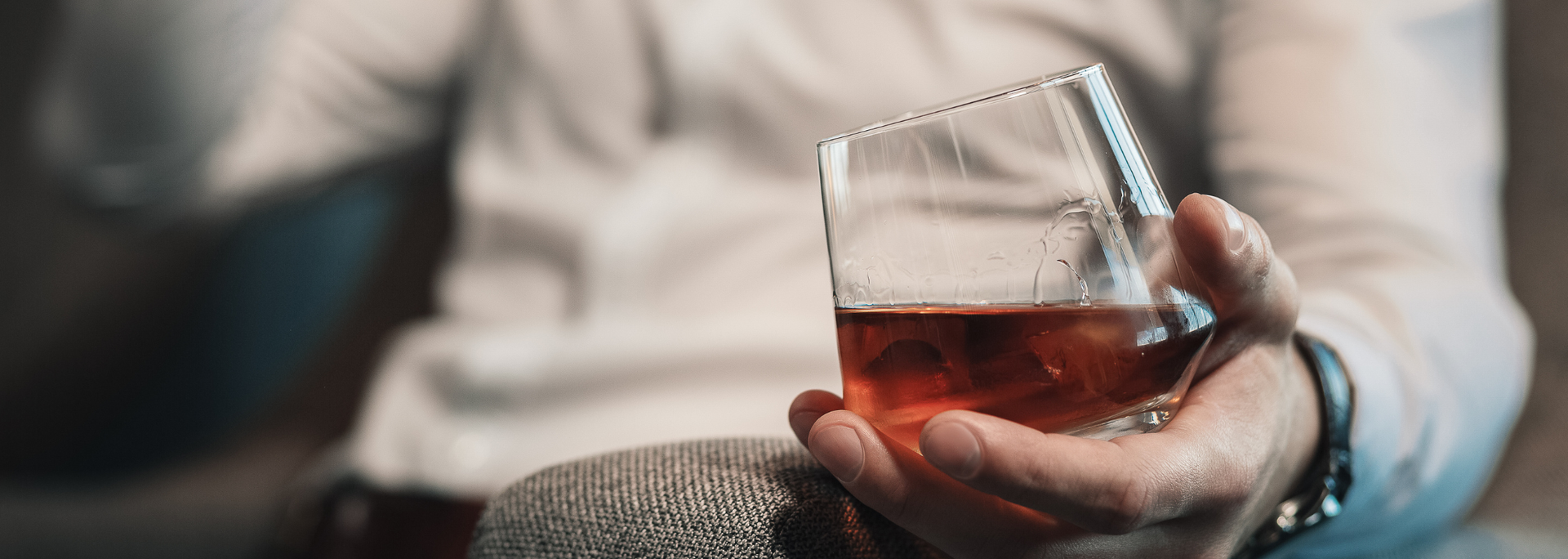 Picture of a person holding a glass of alcohol. 