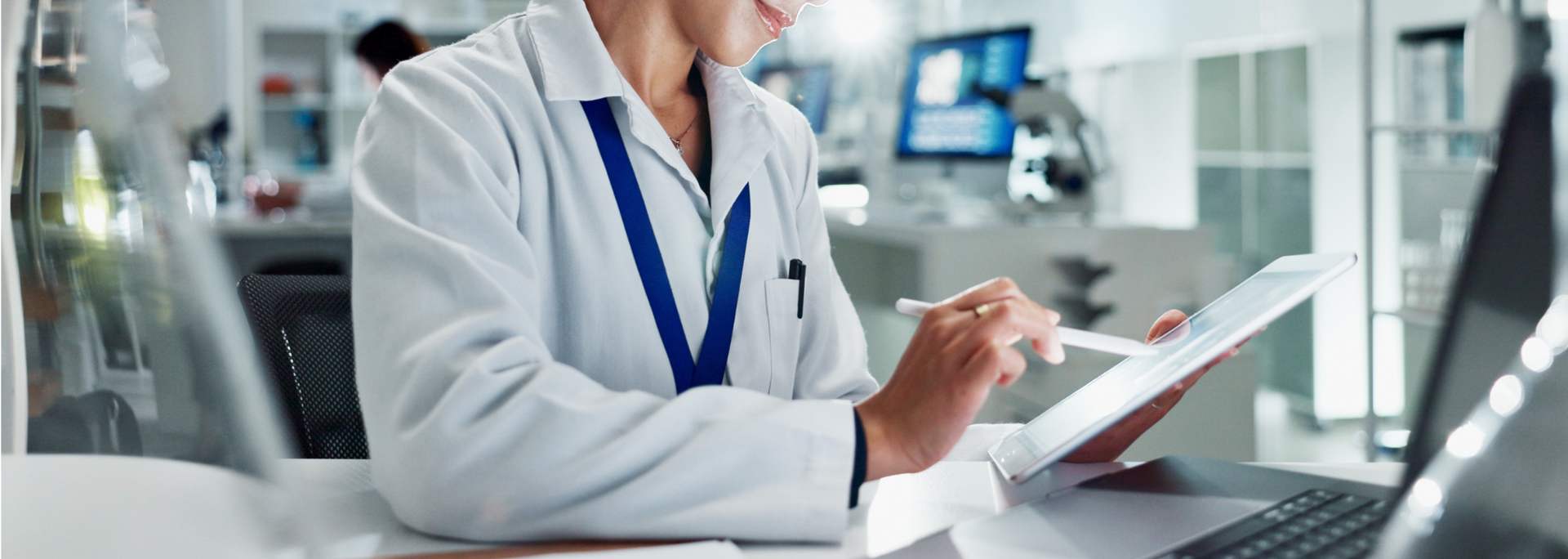 Picture of a medical scientist examining a report on a computer.