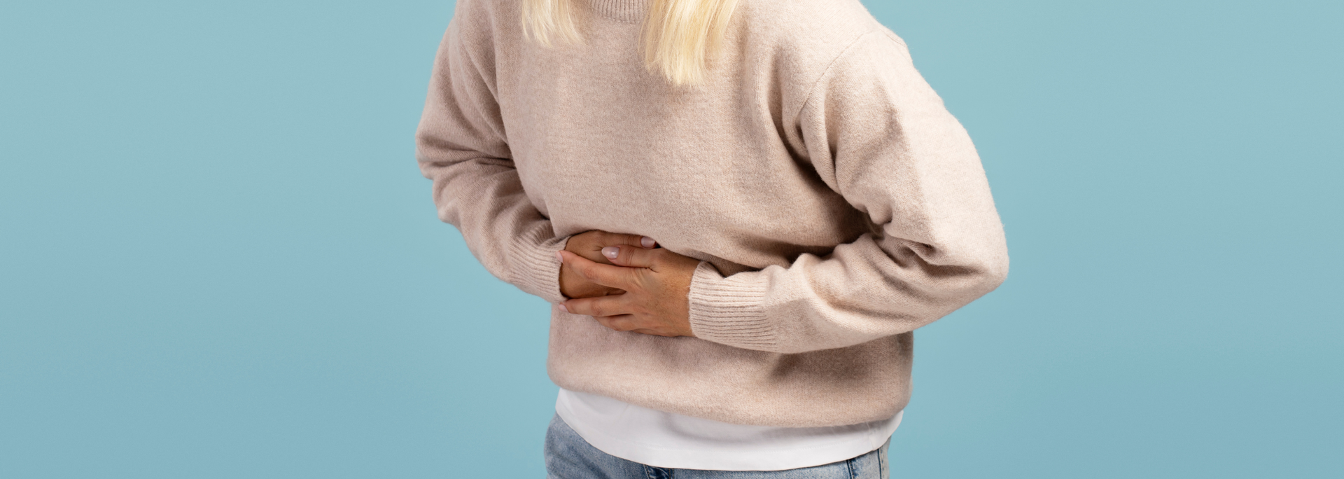 Picture of a woman holding her stomach experiencing nausea. Picture of a woman holding her stomach experiencing nausea.