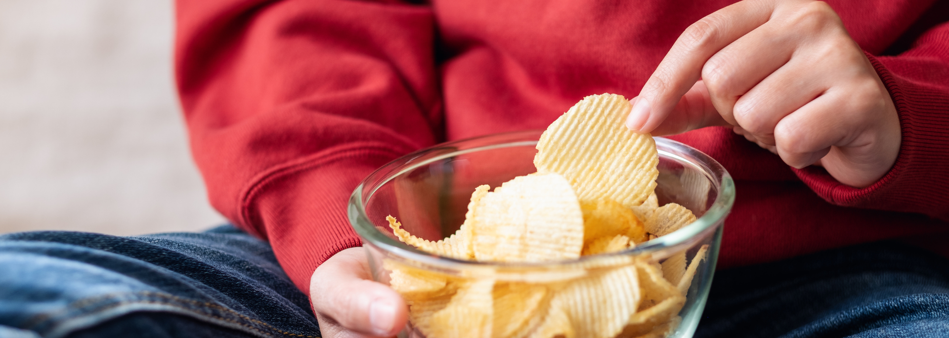 Picture of someone eating crisps. 